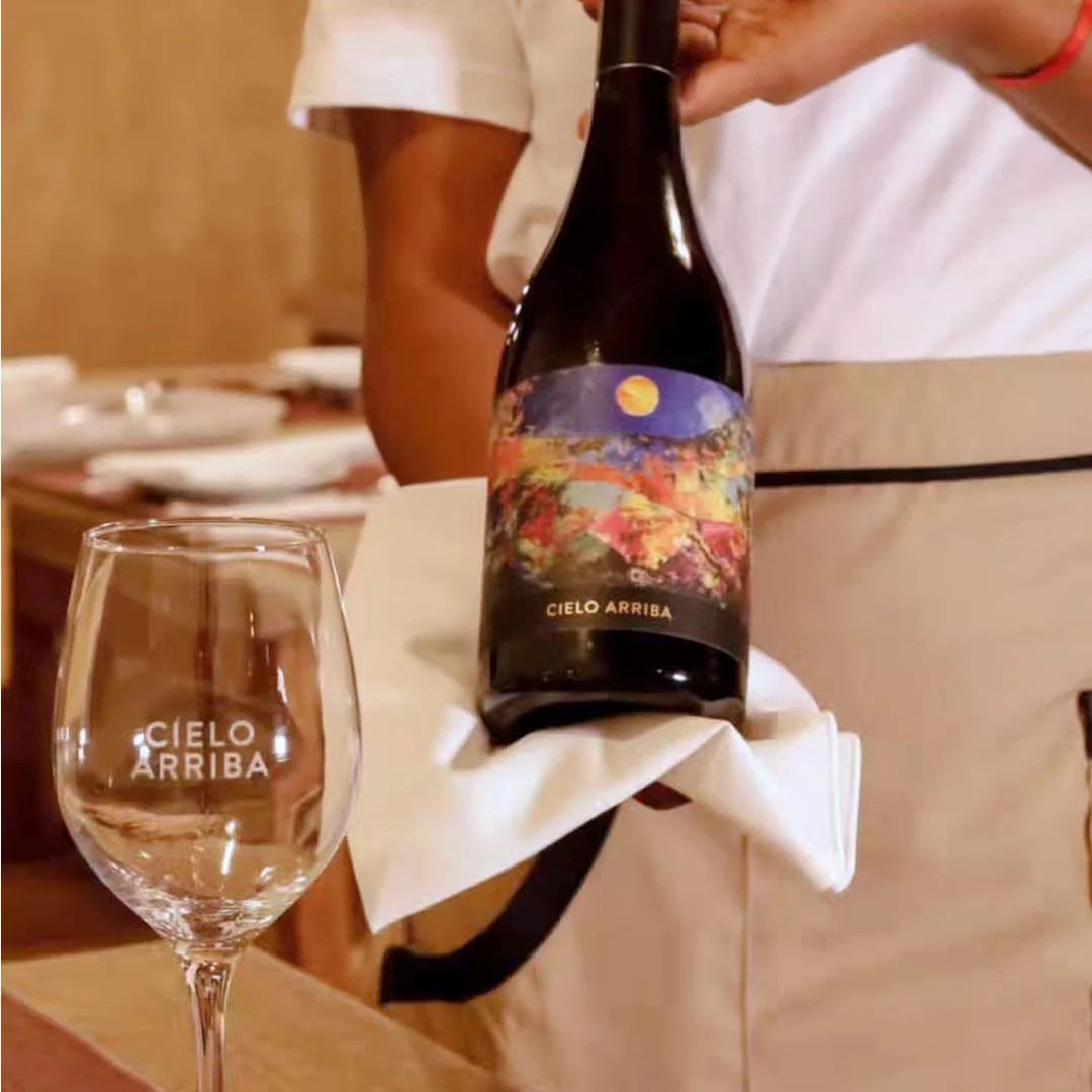 Serving a bottle of Cielo Arriba wine